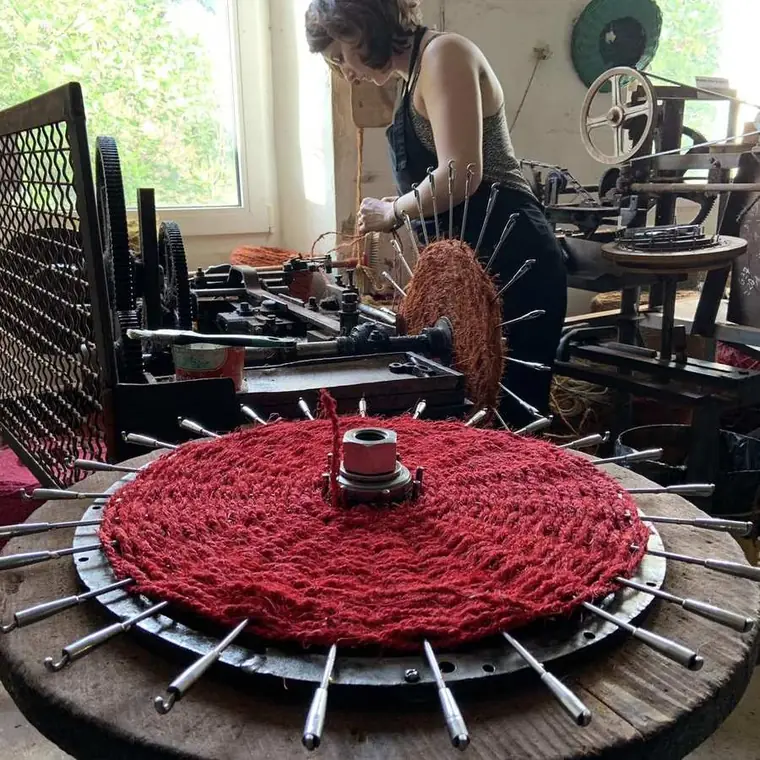 Artisan scourtinière à l'œuvre — tissage d'un scourtin rouge sur machine centenaire à Nyons